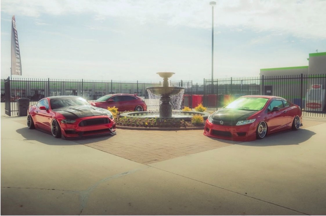 Red Mustang and Honda Civic at community event fountain